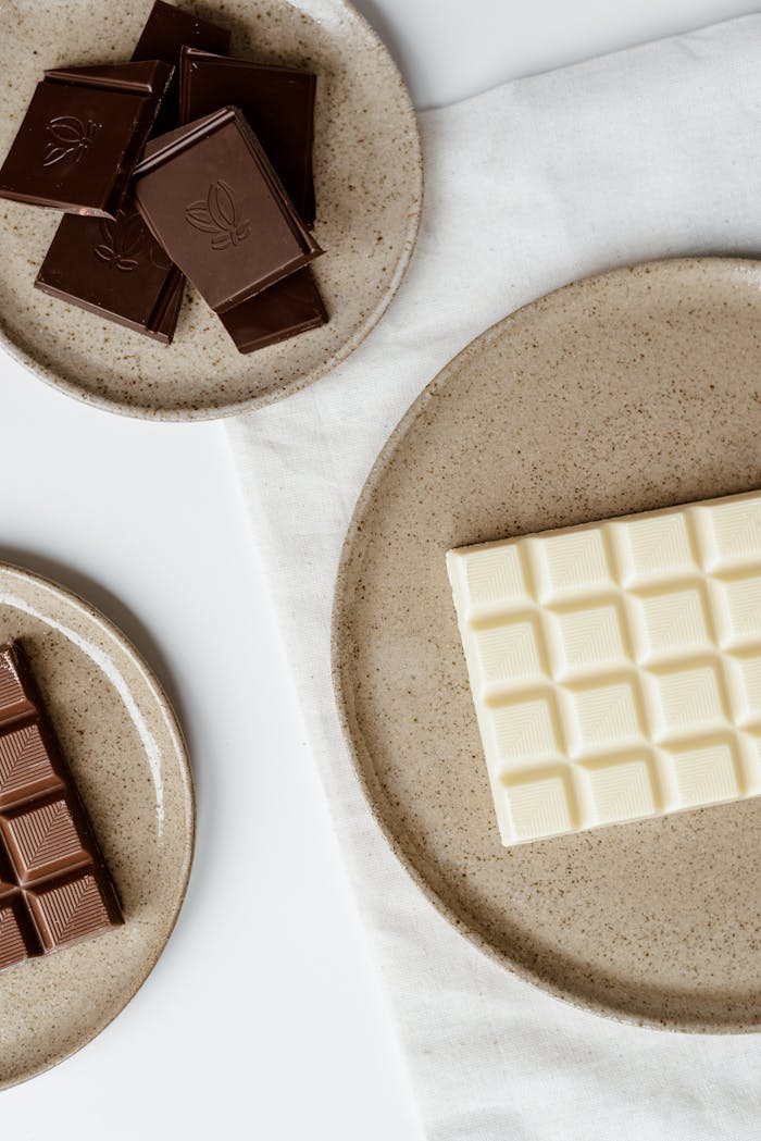 Top view of composition of delicious sweet chocolate on ceramic plates on table